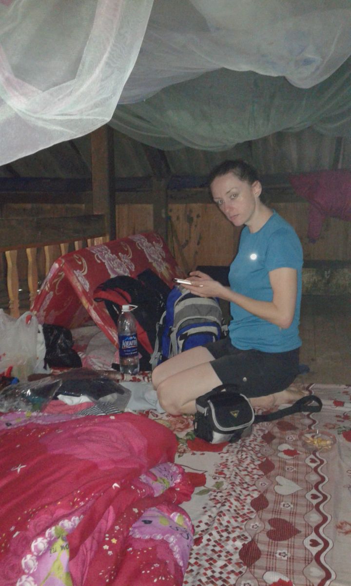 Kobieta siedząca na legowisku pod moskitierą na strychu.