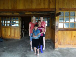 Turystki z lokalną rodziną przed wejściem do domu w Sapa.