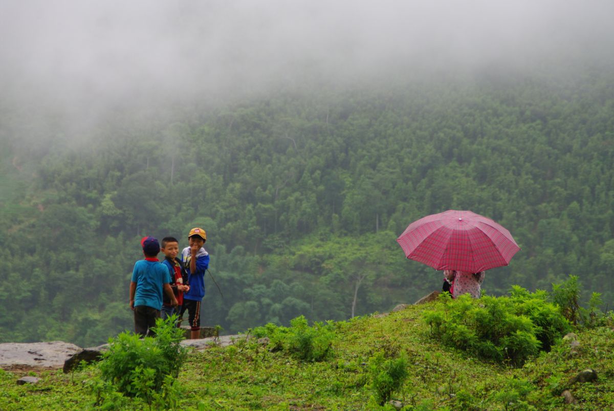 Dzieci stojące na wzgórzu spowitym mgłą w Sapa.