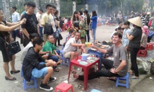 Ludzie jedzący przy małych stolikach na targu w Sapa.