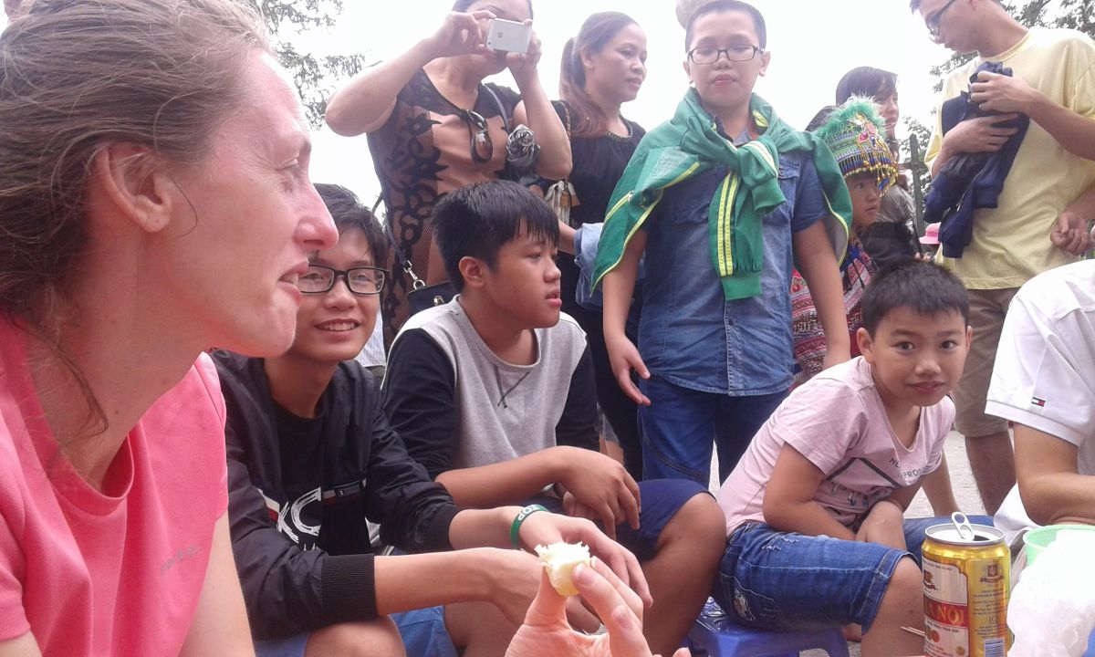 Zbliżenie na grupę osób rozmawiających na targu w Sapa.