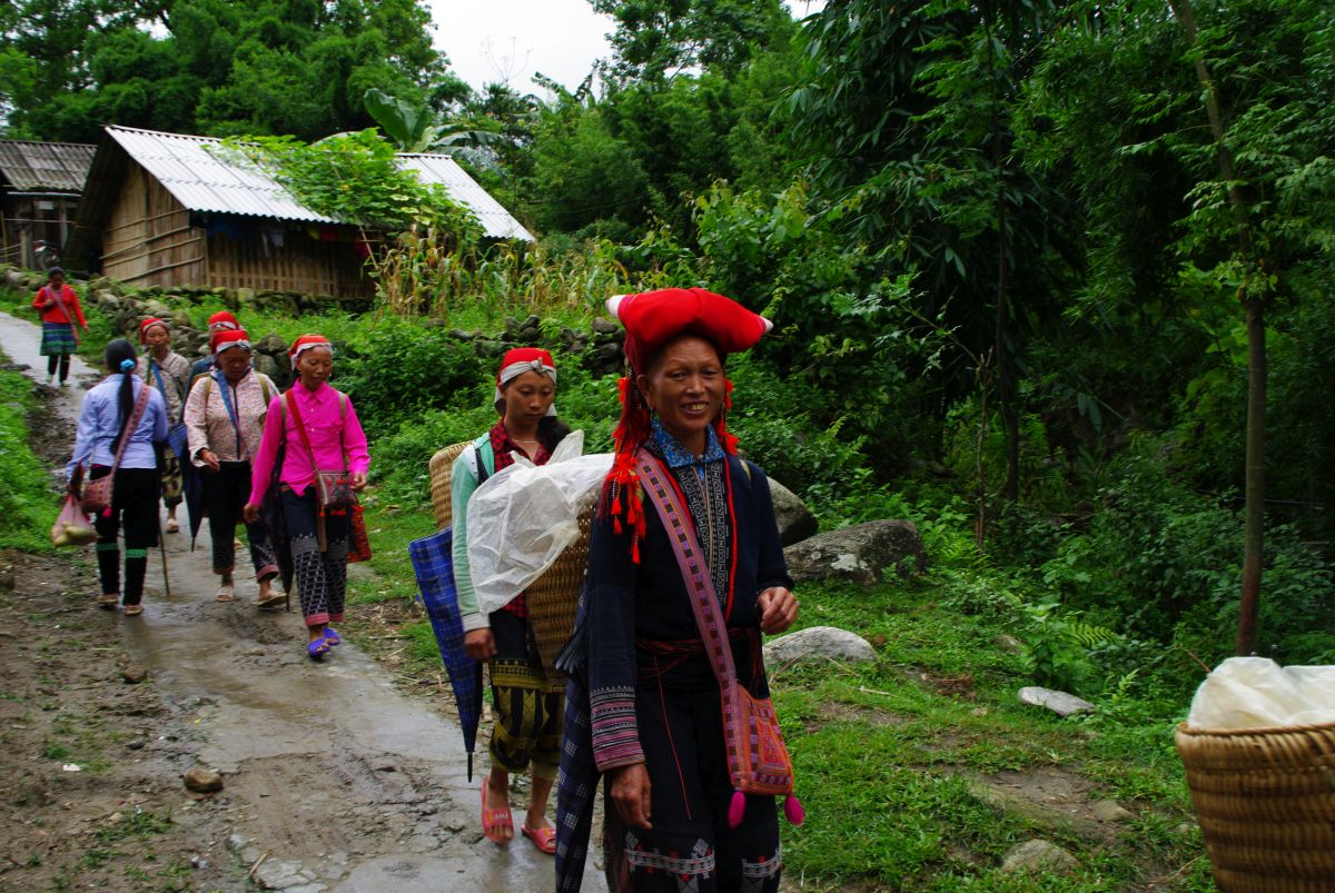 Kobiety w tradycyjnych strojach idące ścieżką w Sapa.
