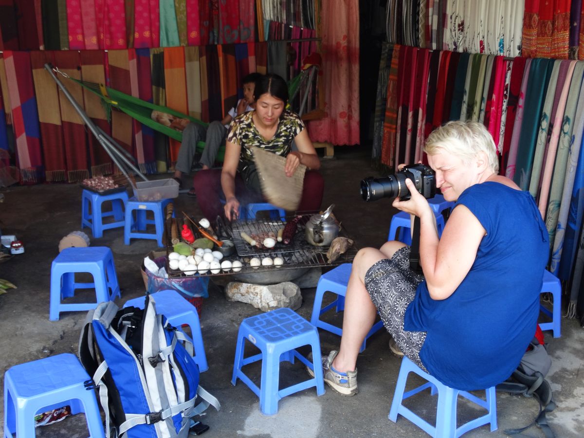 Kobieta fotografująca lokalne jedzenie na grillu w Sapa.