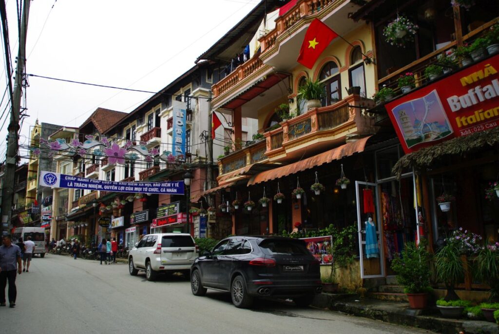 Ulica w Sapa z kolorowymi budynkami i flagami Wietnamu.